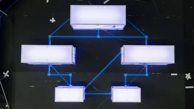 Tournament analyst at a desk with dual monitors displaying statistical sheets